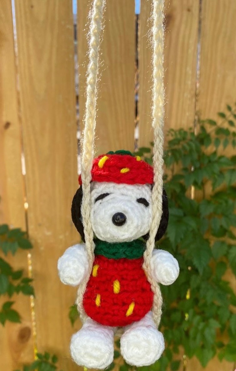Snoopy in a strawberry outfit on a crochet swing