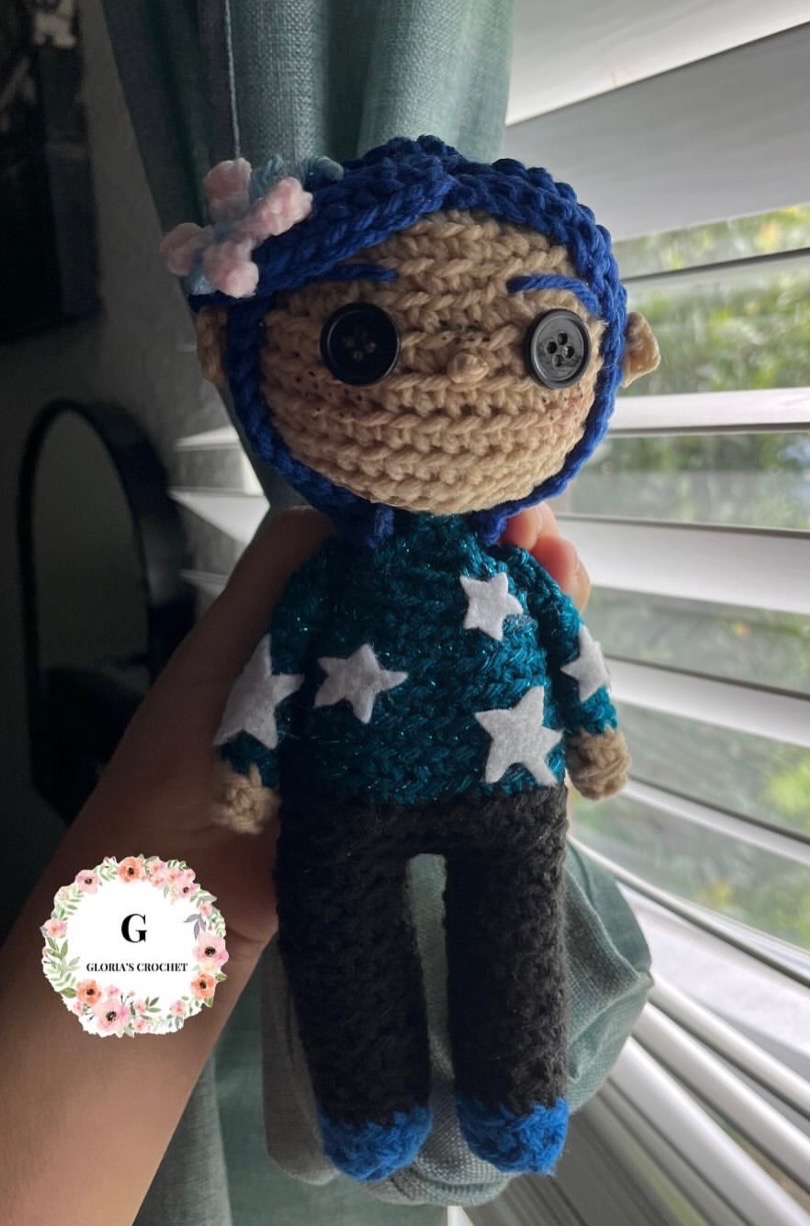 Blue-haired crochet character plushie wearing a star sweater