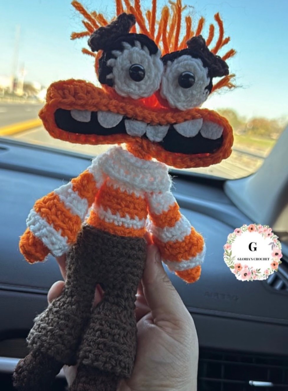 Orange monster crochet character plushie with a wide toothy smile