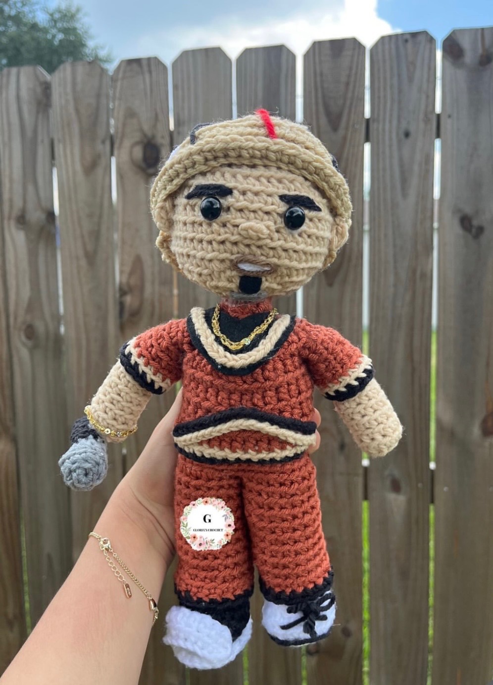 Crochet character plushie in a rust orange outfit
