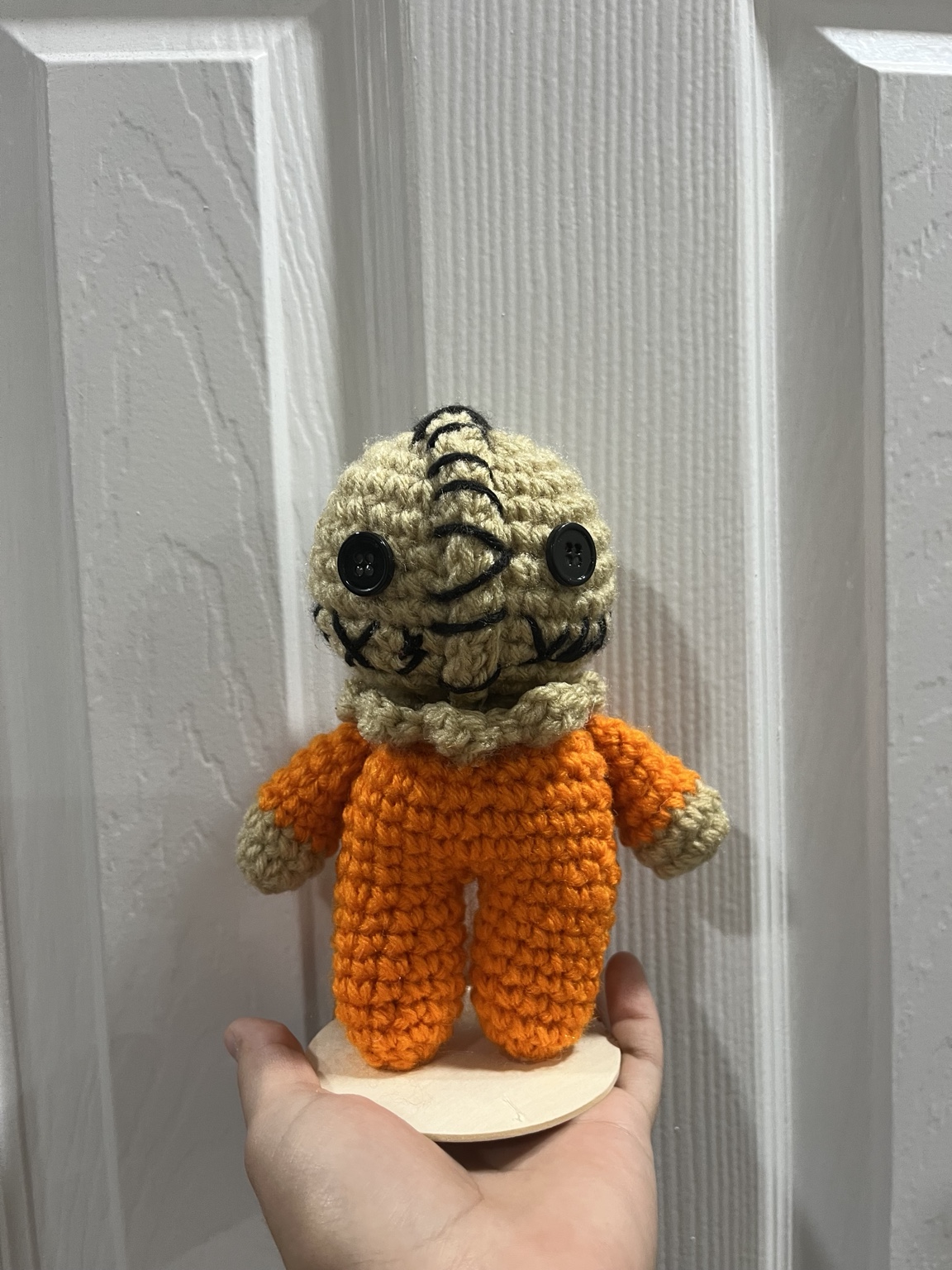 Stitched beige crochet character plushie in an orange jumpsuit