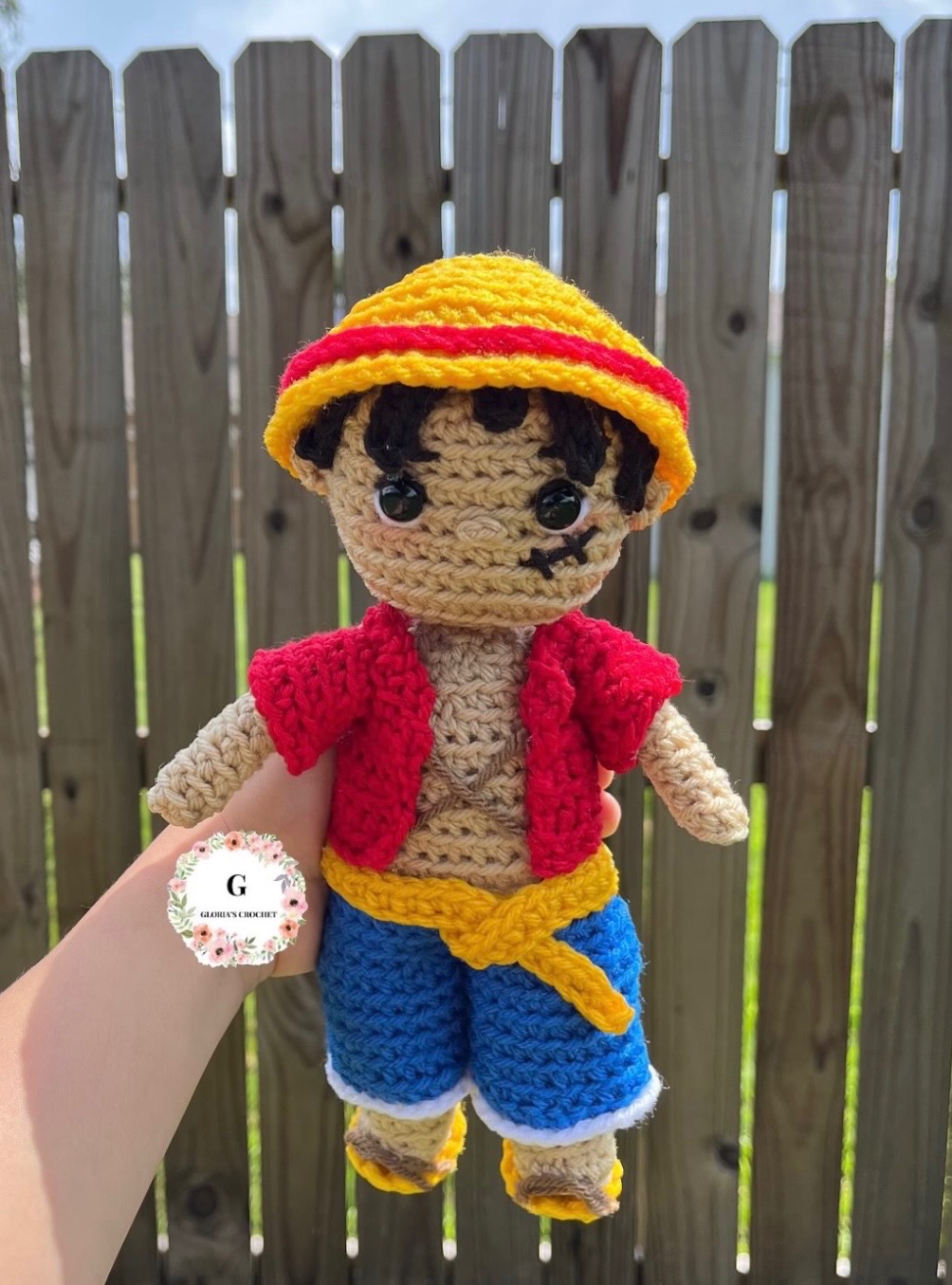 Handmade crochet doll with a yellow hat and red vest